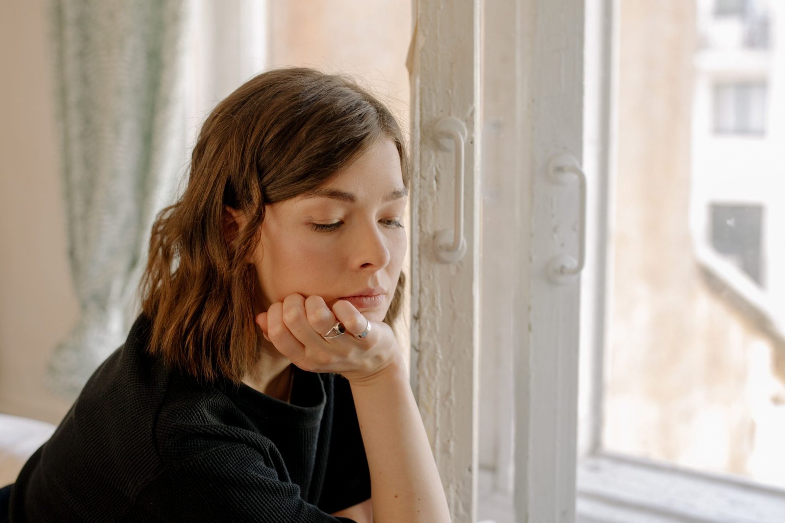woman sitting alone thinking about signs he's emotionally unavailable