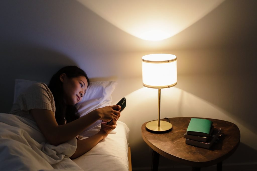 woman checking phone waiting for emotionally unavailable man to text
